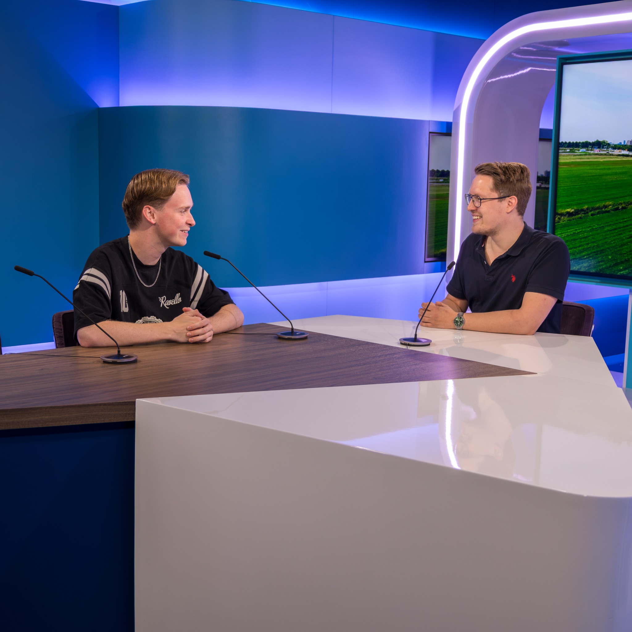 Twee gasten aan tafel in de tv-studio van Dtv